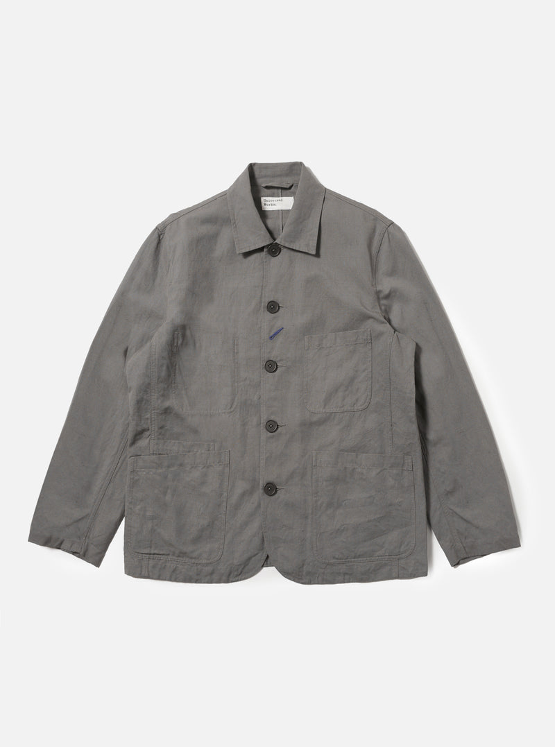 The Mid Grey Linen Slub Weave Bakers Jacket is shown as a flat lay against a plain white background. The jacket features a five-button front closure, a structured collar, and four asymmetrical patch pockets on the front, including one with a buttoned flap. The mid-grey fabric has a visible slubbed texture from the linen and cotton blend.