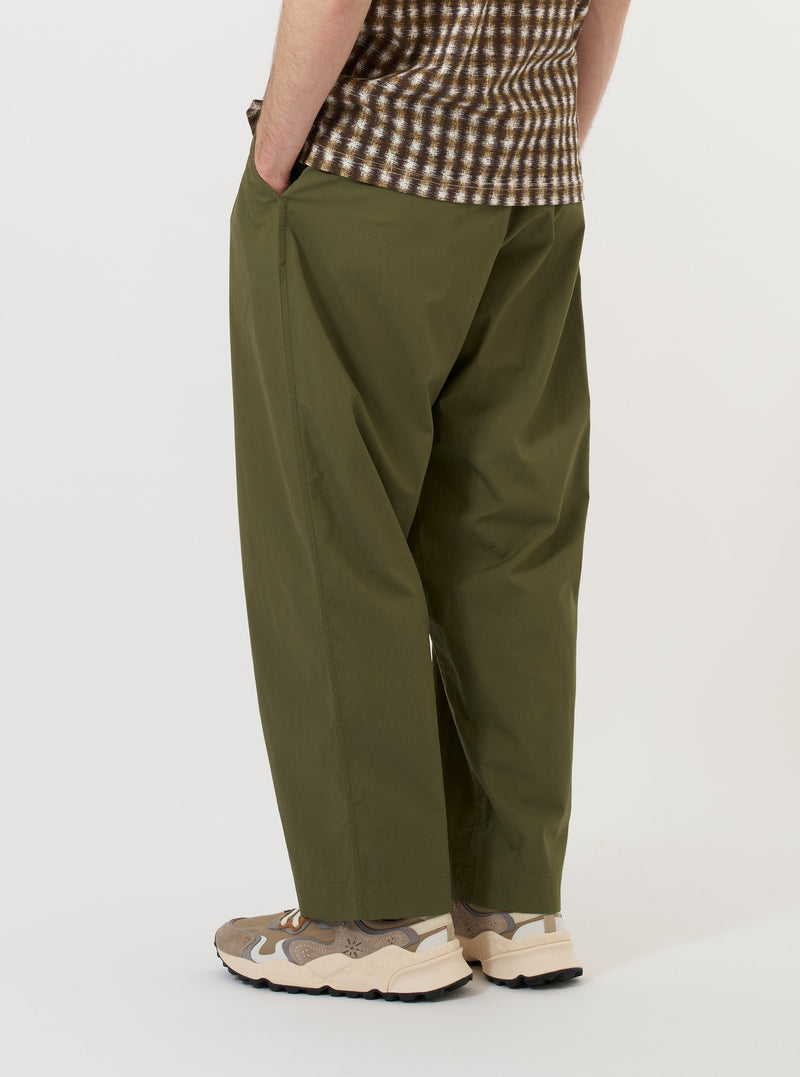 The Olive Broadcloth Oxford Pant is displayed flat against a plain white background. The image focuses on the rear of the trousers, highlighting the elasticated waistband with belt loops and two rear pockets: one a buttoned flap pocket and the other a jetted buttoned pocket. The wide, loose leg silhouette is clearly visible.