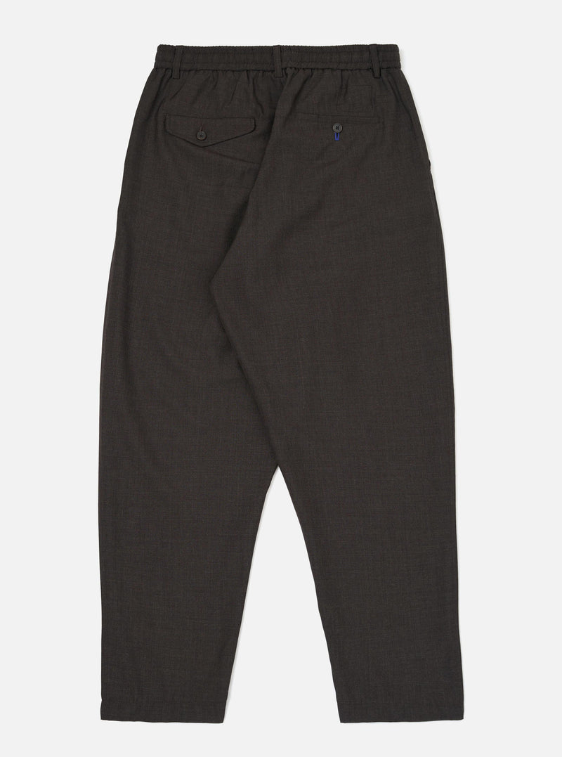 The back of the Brown Marl Tropical Suiting Pleated Track Pant is displayed flat against a plain white background. The trousers feature a tapered leg, an elasticated waistband, and two distinct rear pockets, including one with a buttoned flap.