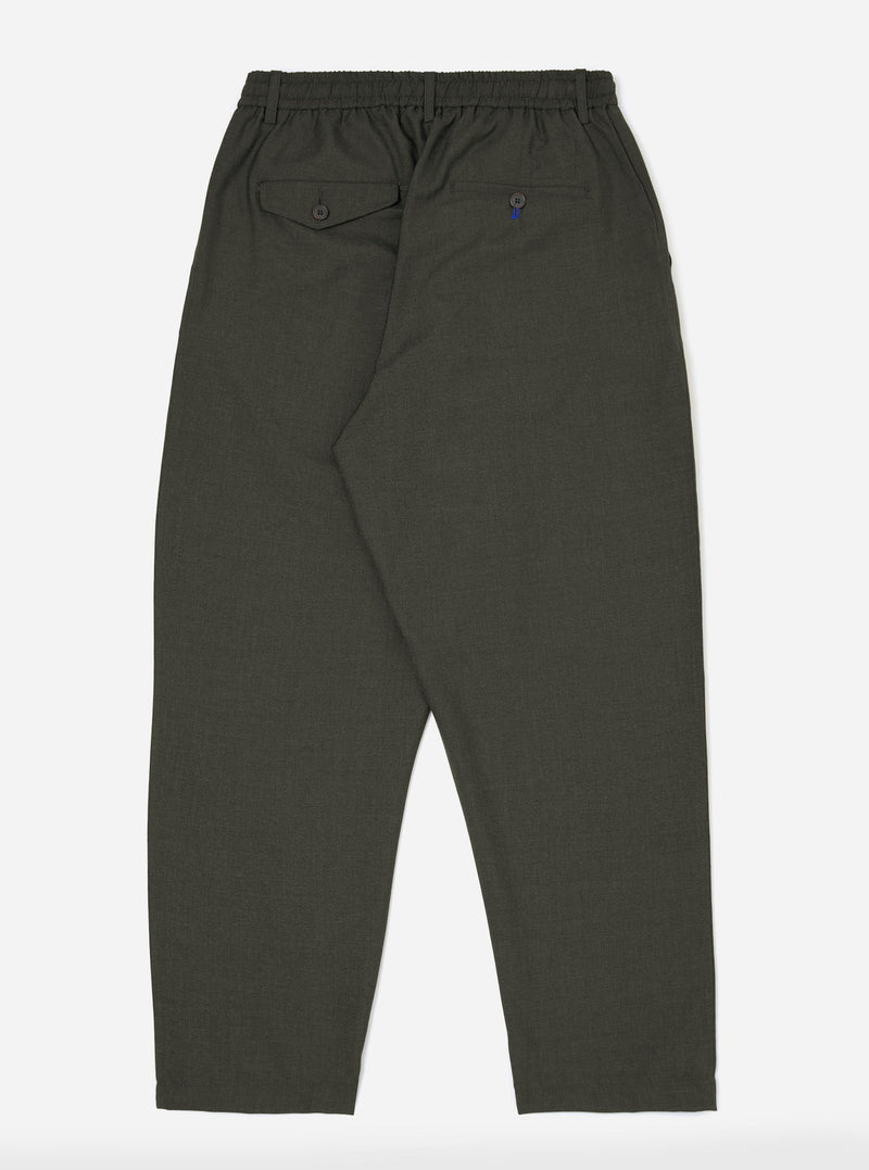 The back of the Olive Marl Tropical Suiting Pleated Track Pant is displayed flat against a plain white background. The olive green trousers feature a tapered leg, an elasticated drawstring waistband, and a single rear buttoned pocket.