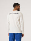 Back view of a model wearing the Paraboot x Universal Works Ecru Single Jersey Long Sleeve Tee. The tee is ecru with black text on the back. Shot on a white background.