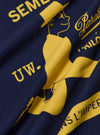 A close-up fabric swatch of the Paraboot x Universal Works Navy Single Jersey Print Tee highlights the deep navy blue color and the fine knit texture of the single jersey cotton fabric. The material fills the frame, providing a detailed view of the garment's construction and color.