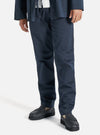 A model wears the Navy Twill Aston Pant, a slim-fit navy pant, paired with black loafers. Shot in a studio setting on a white background.