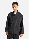 A model wears the Black Twill Kyoto Work Jacket against a white backdrop. The jacket is a relaxed fit with a tie waist and patch pockets.