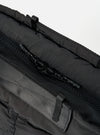 Close-up of the Topologie x Universal Works Black UW Tech Helmet Bag. Shows black nylon material, zipper details, and webbing straps against a white backdrop.