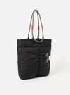 Topologie x Universal Works Black UW Tech Helmet Bag on a white background. The bag is black with rope handles and small patches.