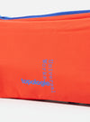 Close-up of the Topologie x Universal Works Red UW Tech Bottle Sacoche Medium. Features a red material with blue accents and blue lettering. Shot in a studio setting.
