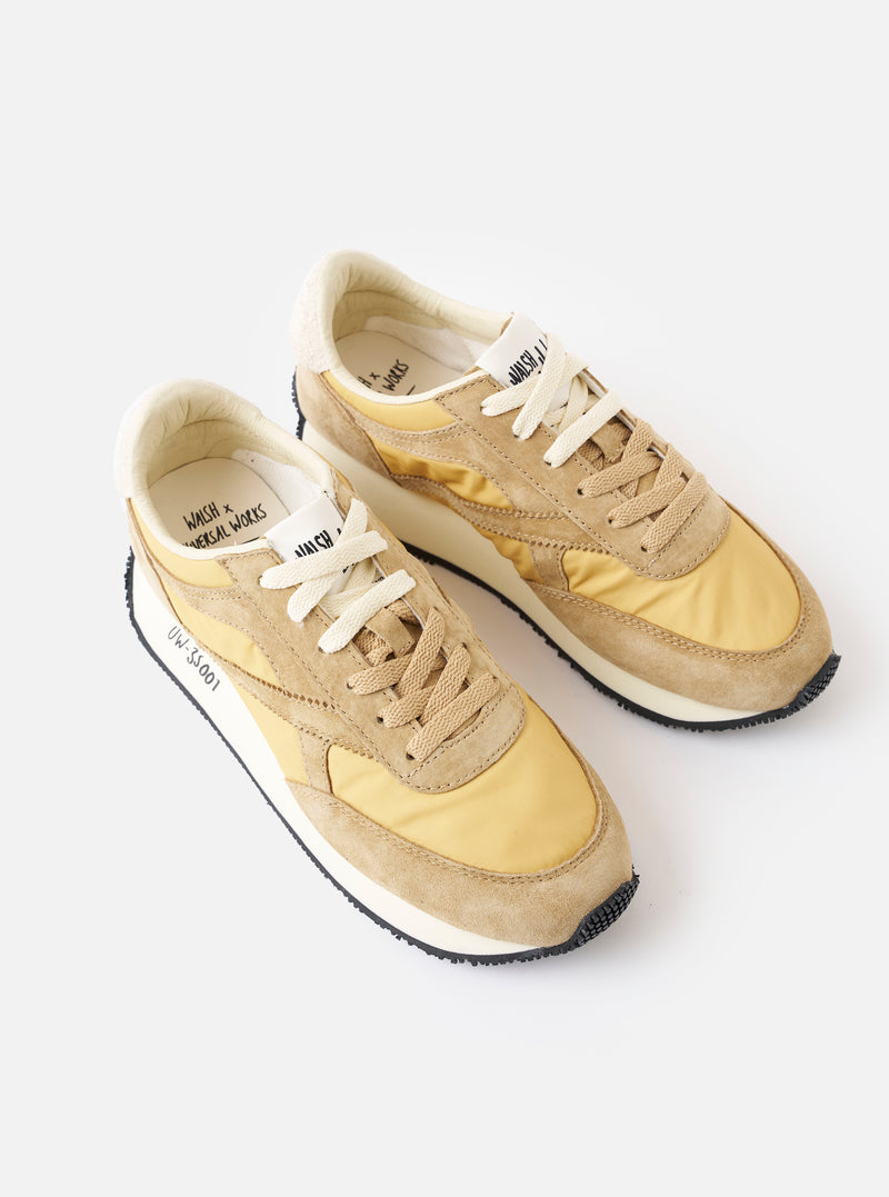 A top-down view of the Walsh x Universal Works Tornado in Beige Leather/Canvas against a plain white background, highlighting the inner leather lining, branded footbed, tongue label, and beige laces.