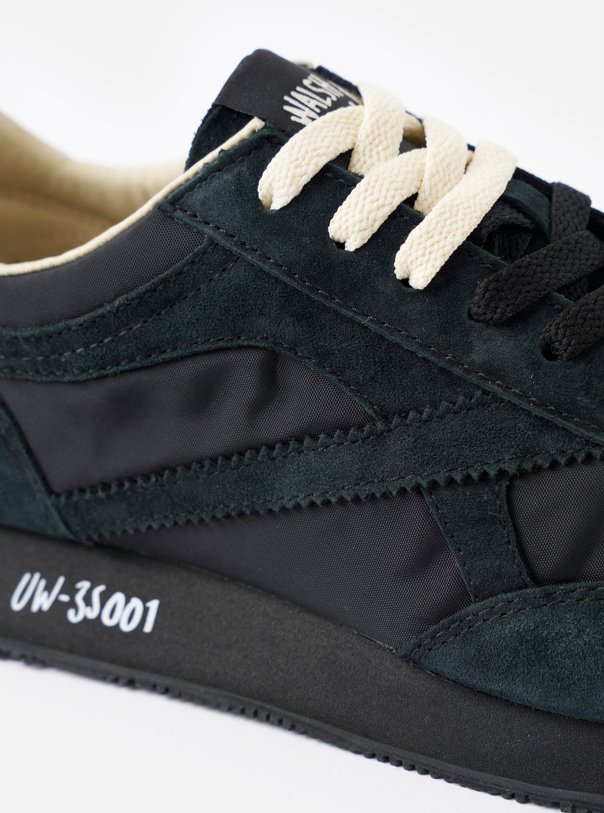 A rear view of the Walsh x Universal Works Tornado sneaker in Black Leather/Canvas on a plain white background, showing the structured heel tab, padded ankle collar, and rubber outsole profile.