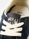 A product shot featuring the pair of Walsh x Universal Works Tornado sneakers in Black Leather/Canvas positioned together on a plain white background to display the complete footwear design.