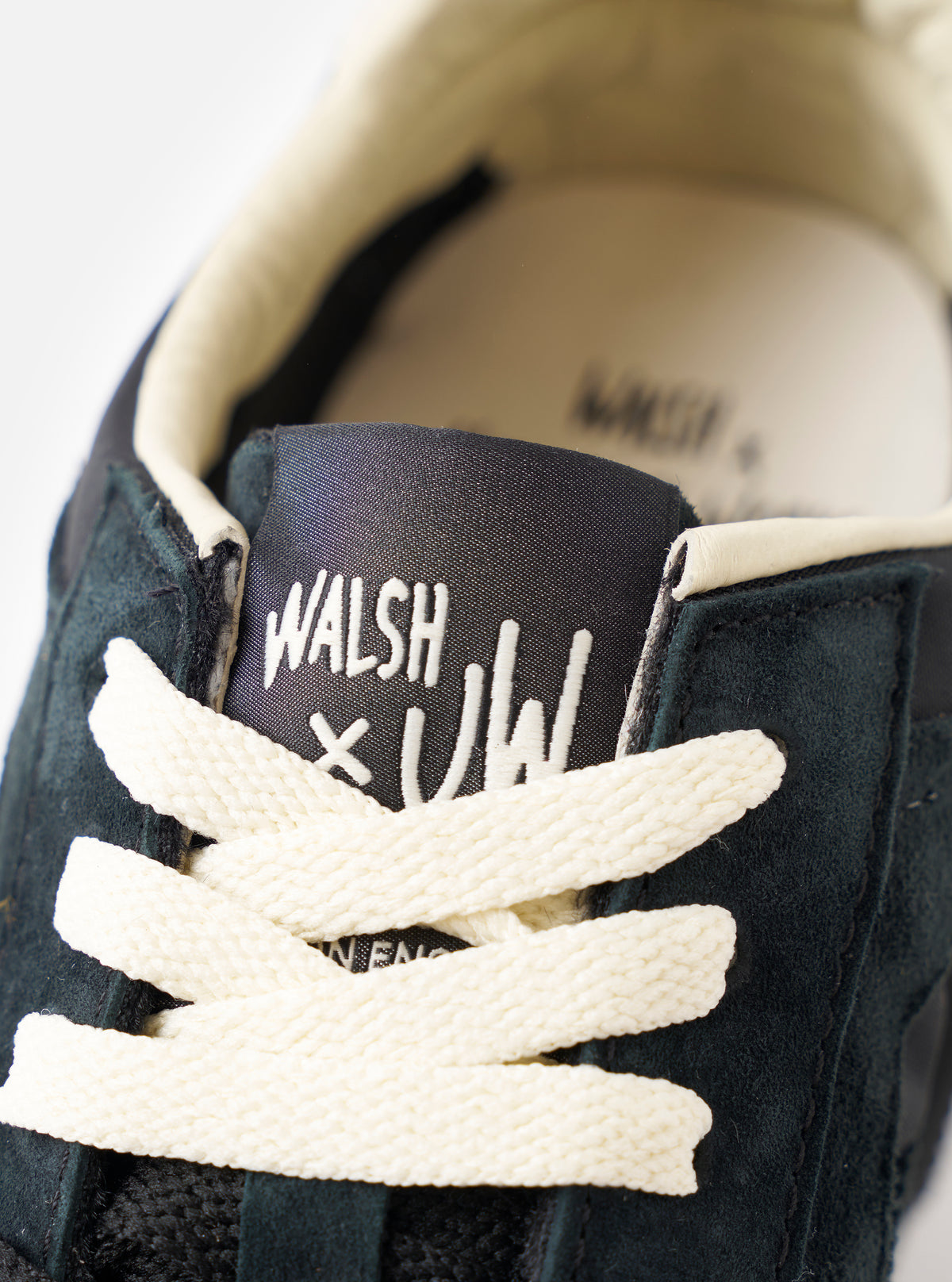A product shot featuring the pair of Walsh x Universal Works Tornado sneakers in Black Leather/Canvas positioned together on a plain white background to display the complete footwear design.