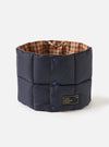 The TAION x Universal Works Reversible Dark Navy Military Line Neck Warmer on a white background. It's navy with a brown houndstooth interior and blue buttons.