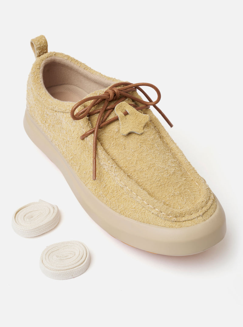The Wander etc. FD/08 Low in Dune/Gum Hairy Suede is shown from a rear three-quarter angle as a flat lay against a white background. The shoe features a textured dune-colored hairy suede upper, a prominent gum rubber outsole, and thick tonal laces. Branding is visible on the heel, and the interior reveals a black nylex insole.
