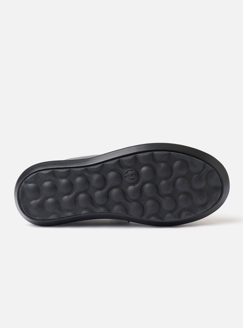 The Wander etc. Laze in Black Nappa Leather is shown as a flat lay against a plain white background. The footwear is a backless mule style featuring a smooth black nappa leather upper and a chunky black phylon and gum outsole. The interior reveals a cork footbed with a printed logo.