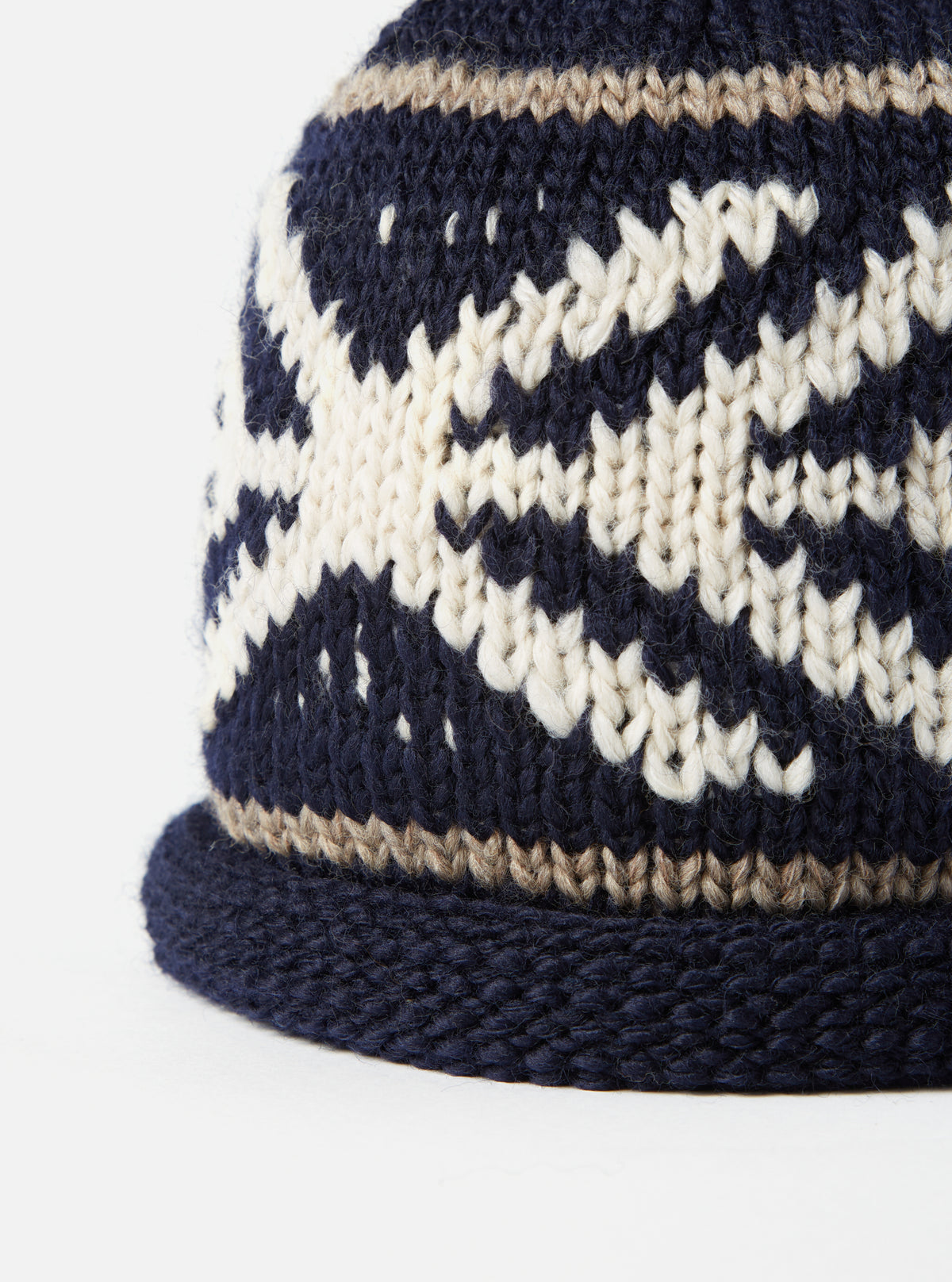 Detailed close-up view of the cableami® Navy Wool Jacquard Watch Cap on a plain white background, highlighting the rich jacquard knit pattern, soft wool yarn texture, and neat stitching along the turn-up cuff.