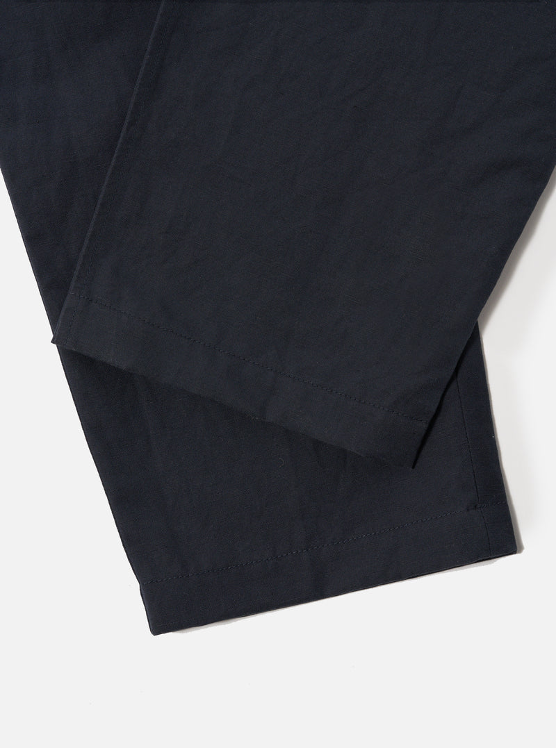 Close-up of the Navy Linen Slub Weave Oxford Pant on a white background, showcasing the fabric's texture and the pant's hem.