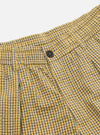 Close-up of the Yellow Japanese Seersucker Pleated Track Short. Features a yellow and gray checkered pattern, pleated design, and button closure. Shot on a white background.