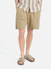 A model on a white background wears the Yellow Japanese Seersucker Pleated Track Short. The shorts are yellow with a subtle checkered pattern. The model is also wearing sandals.