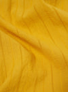 Close-up of the Mustard Dobby Self Stripe Camper Shirt fabric. The mustard-colored material features a subtle dobby stripe pattern. The shirt is laid flat on a neutral surface.