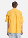 Back view of a model wearing a Mustard Dobby Self Stripe Camper Shirt. The shirt is a textured mustard color with a subtle stripe pattern. Shot against a white background.