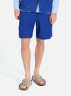 A model on a white background wears the Work Blue Summer Cord Alva Short. The shorts are blue corduroy, paired with sandals and a striped shirt.
