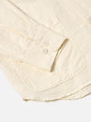 Close-up of the Ecru Linen Cotton Shirting Travail Overshirt on a white background. Shows the ecru color, linen texture, buttoned cuff, and pocket detail.