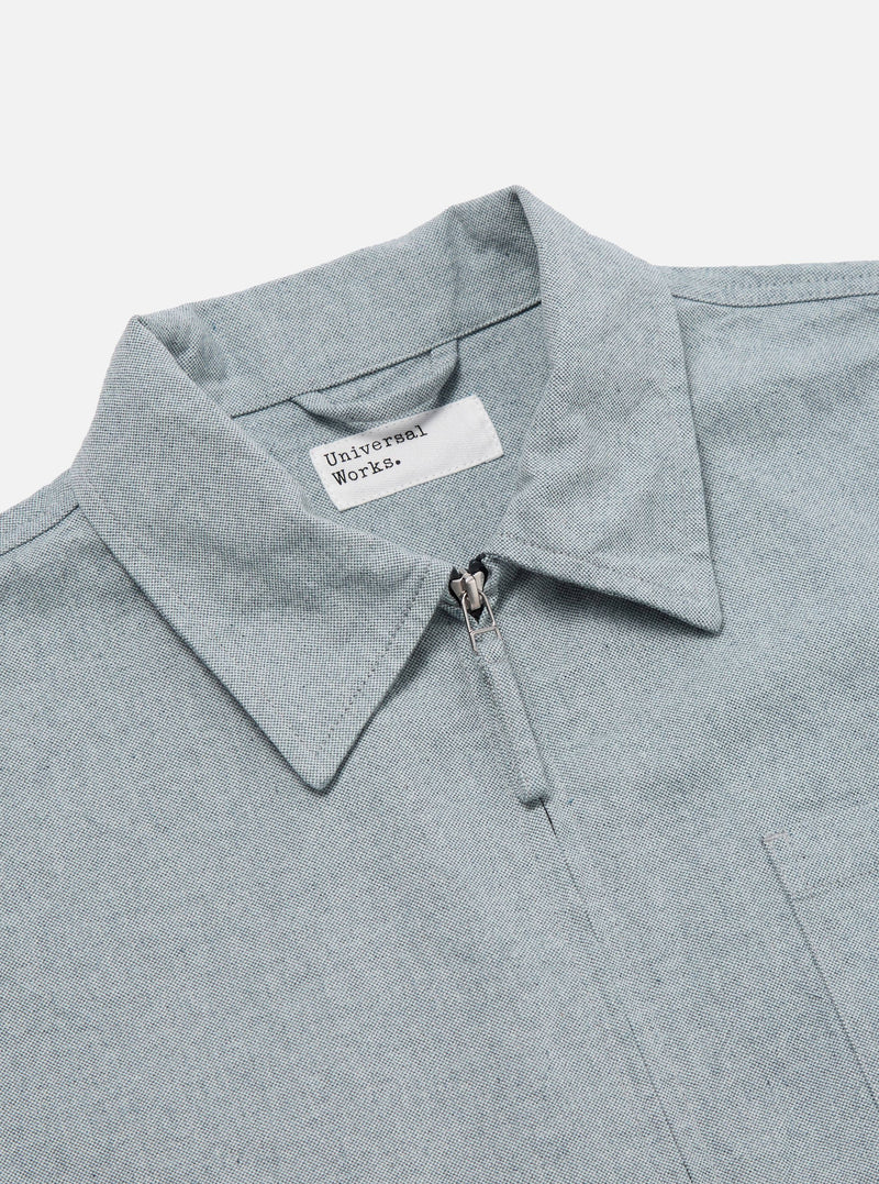 Close-up of the Indigo Reworked Jean Cloth Rose Bowl Jacket in light blue denim. Features a collared neck, front zipper, and chest pocket. Shot on a white background.