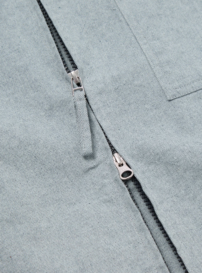 Close-up of the Indigo Reworked Jean Cloth Rose Bowl Jacket, showcasing the light blue denim texture and silver zipper. The jacket is laid flat, highlighting the material.