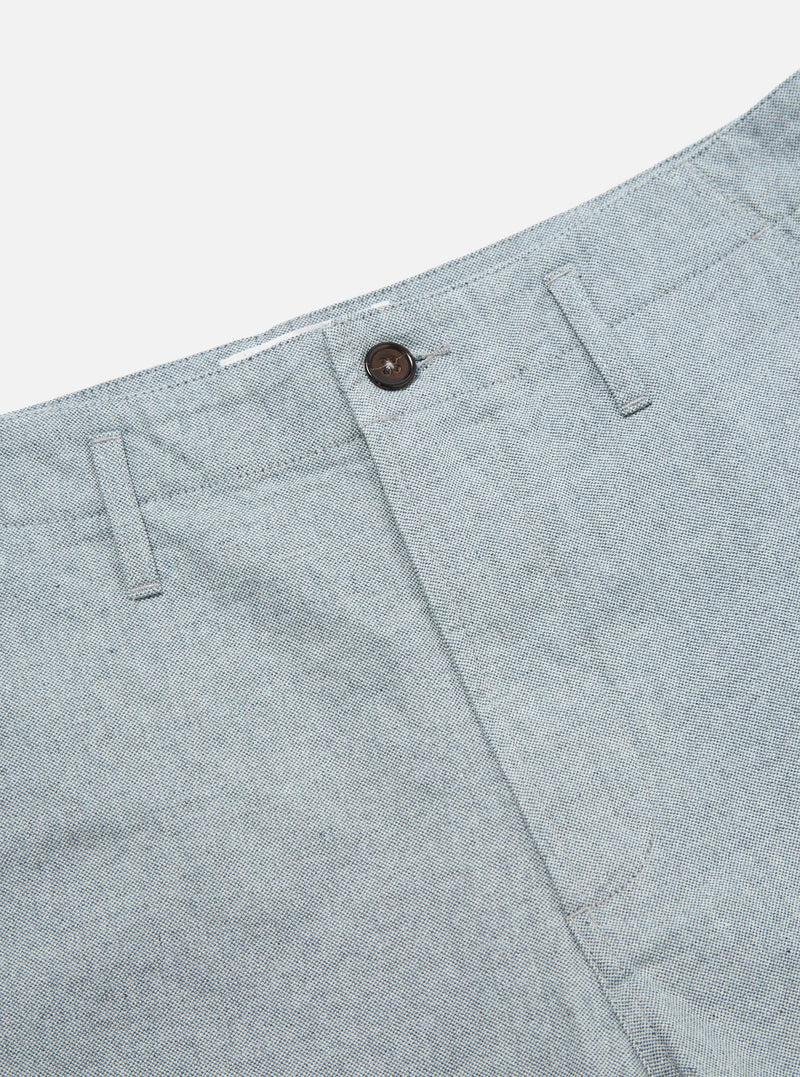 Close-up of the Indigo Reworked Jean Cloth Alva Short. Light blue denim texture with a brown button. Shot on a white background.