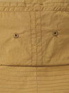 Close-up of the Dark Sand Peach Recycled Nylon Beach Hat. The hat is peach-colored with visible stitching and ventilation holes. The background is a plain white surface.