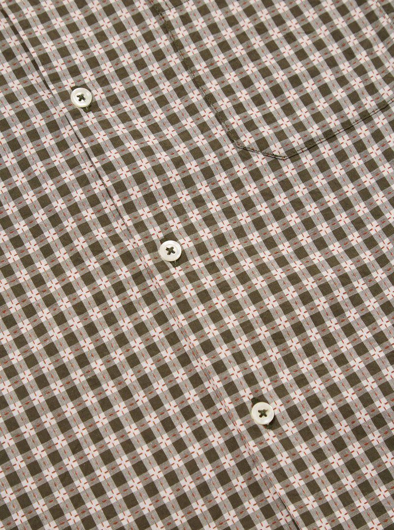 Close-up of the Olive Dobby Check Road Shirt, showcasing its olive and white check pattern with small red accents. White buttons are visible on the shirt's front.