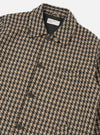 Close-up of the Sand Cortina Tweed Long Swing Coat. The tweed is a houndstooth pattern in sand, brown, and black. The coat is buttoned and laid on a white surface.
