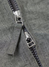 Close-up of the Charcoal Organic Chambray Parachute Liner Jacket. The image shows the zipper with a silver pull tab on the charcoal chambray fabric. 