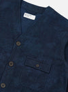 Close-up of the Black/Indigo Denim Camo Cabin Jacket on a white surface. The jacket features a button-up design and a small pocket. The camo pattern is subtle and stylish.