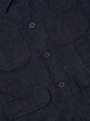 Close-up of the Indigo Brushed Denim Labour Jacket showing the brushed denim texture, pockets, and button details. The jacket is laid flat on a neutral surface.