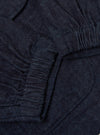 Close-up of the Indigo Brushed Denim Labour Jacket showing the dark blue denim material and pocket detail. The jacket is laid flat on a neutral surface.