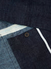 Close-up of the Indigo Brushed Denim Labour Jacket showing the denim texture, button, and white trim. The jacket is neatly arranged on a flat surface.