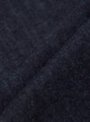 Close-up of the Indigo Brushed Denim Labour Jacket fabric. The brushed denim has a soft texture and rich indigo color. Shot on a simple background.
