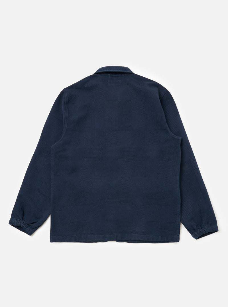 Back view of the Dark Navy Patchwork Weave Cotton Labour Jacket on a white background. The jacket features a subtle patchwork design and a classic collar.