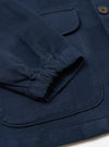 Close-up of the Dark Navy Patchwork Weave Cotton Labour Jacket showing the sleeve, pockets, and textured cotton weave on a white surface.