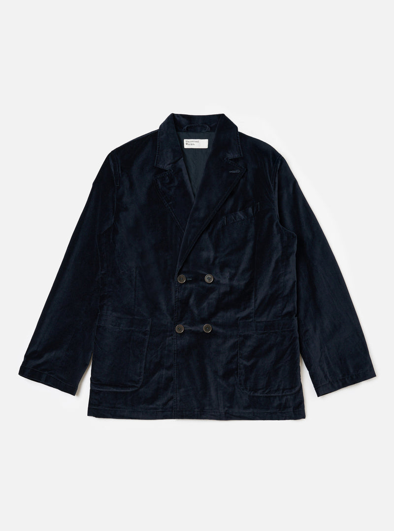 The Navy Velveteen Manor Jacket is displayed on a white background. The jacket is a rich navy color and made of soft velveteen material. It has a relaxed fit and features a double-breasted closure.