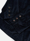 Close-up of the navy velveteen Manor Jacket on a white surface. Shows the jacket's buttons and soft texture. The jacket is neatly folded, highlighting its tailored fit.