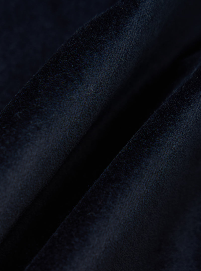 Close-up of the Navy Velveteen Manor Jacket fabric. The soft, plush texture of the navy velvet is highlighted against a simple background.