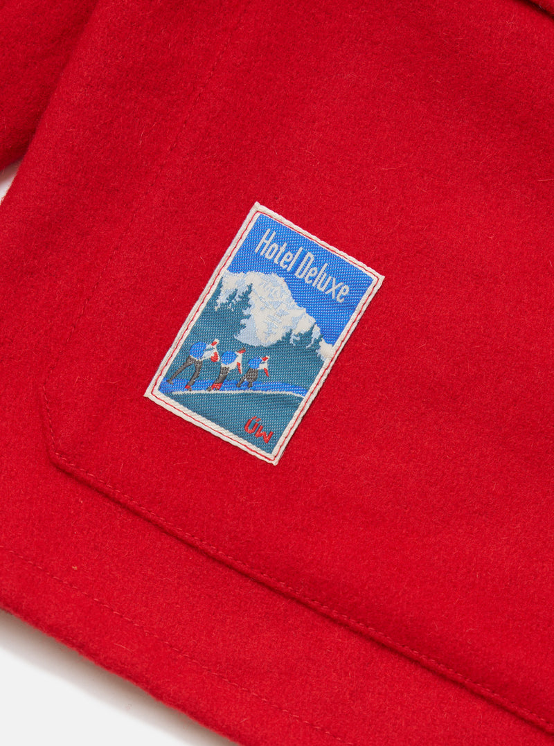 Close-up of the Embroidered Red Mowbray Military Fatigue Jacket showing the red fabric and embroidered patch detail. 
