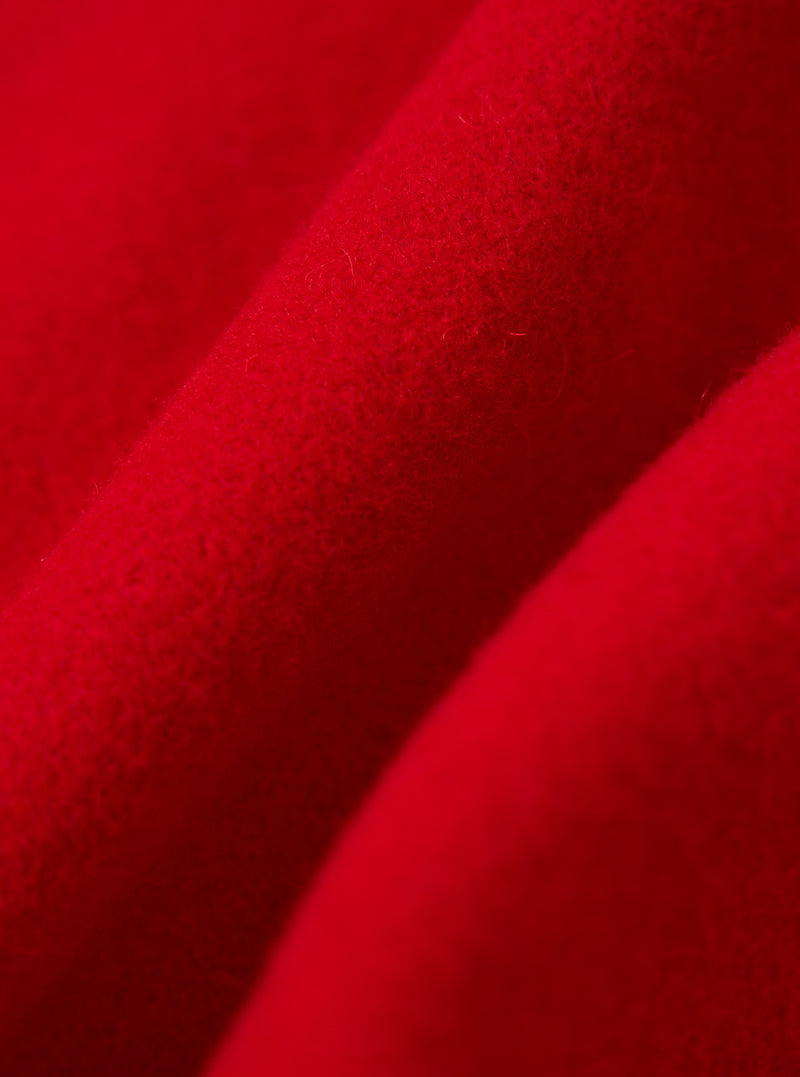 Close-up of the textured, bright red fabric of the Red Mowbray Military Fatigue Jacket, showing the material's weave and soft, folded appearance.