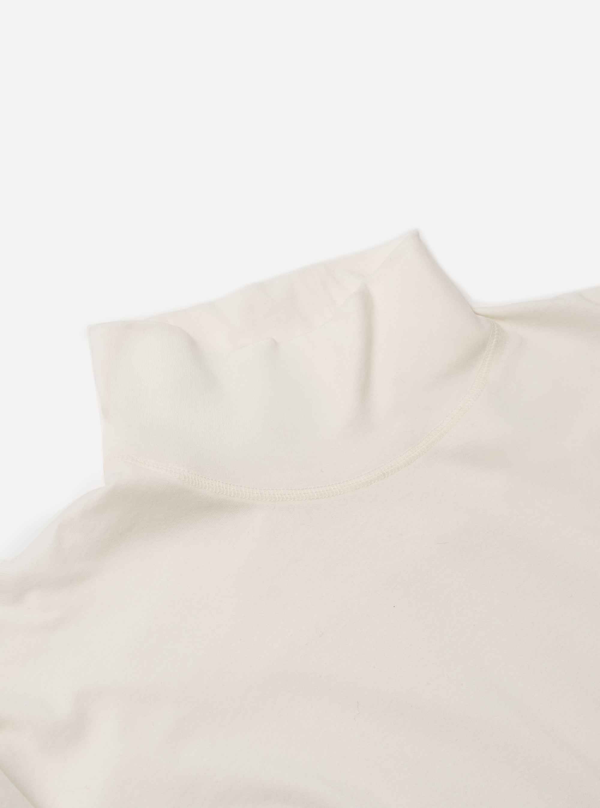 Close-up of the ecru Single Jersey Funnel Neck Tee on a white background. The soft, neutral-colored fabric is highlighted, showing the texture and the funnel neck design.