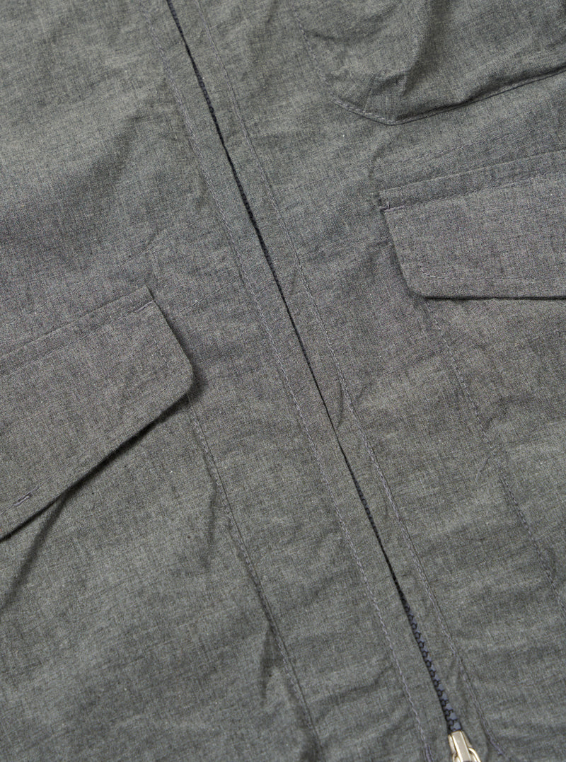 Close-up of the Charcoal Organic Chambray Parachute Liner Gilet, showcasing the fabric texture, pockets, and zipper detail on a flat surface.