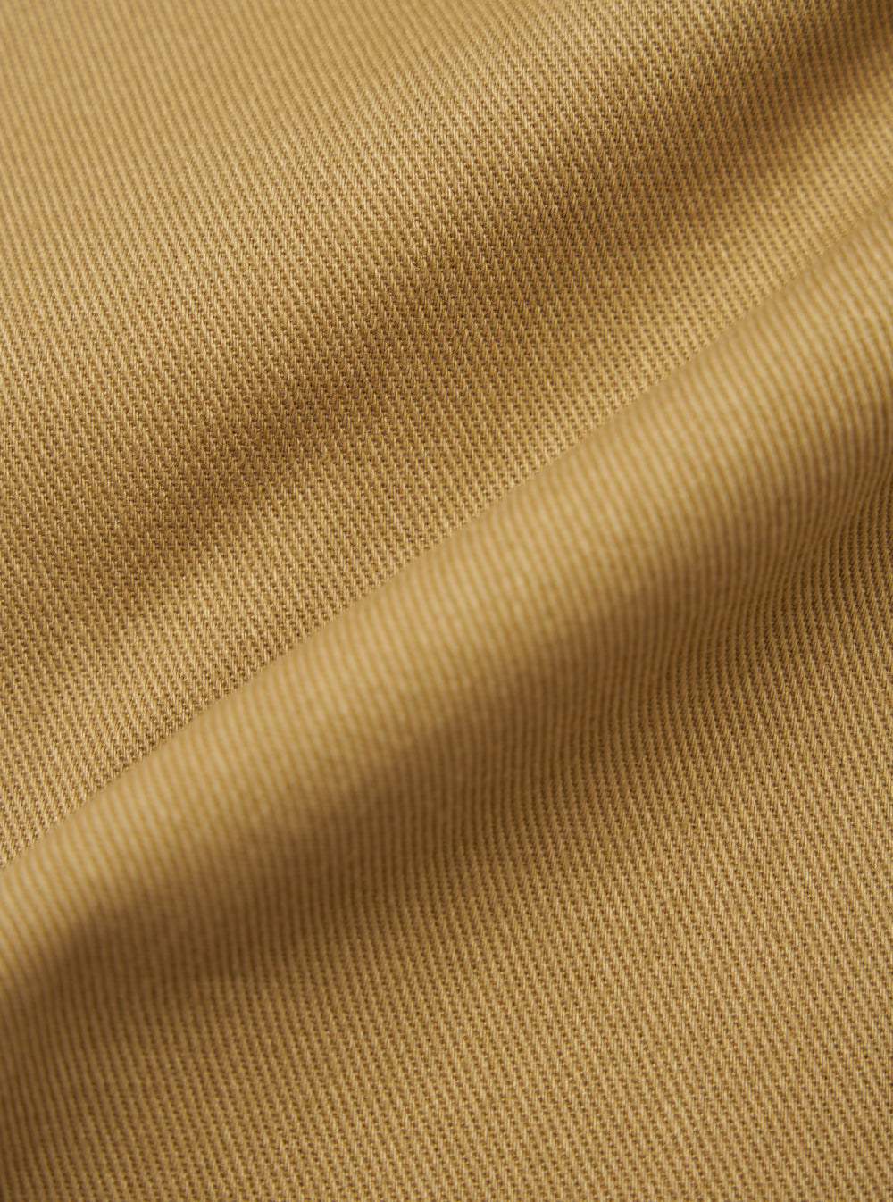Close-up of the twill fabric of the Khaki Works Twill Duke Pant. The material is a light khaki color and has a subtle texture. The fabric is draped to show its quality.