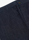 Close-up of Indigo Brushed Denim Military Chino on a white background. The dark wash denim shows the texture and details of the fabric and button.
