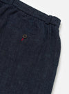 Close-up of the Indigo Brushed Denim Oxford Pant showing the elastic waistband, buttoned pocket, and brushed denim texture on a white background.